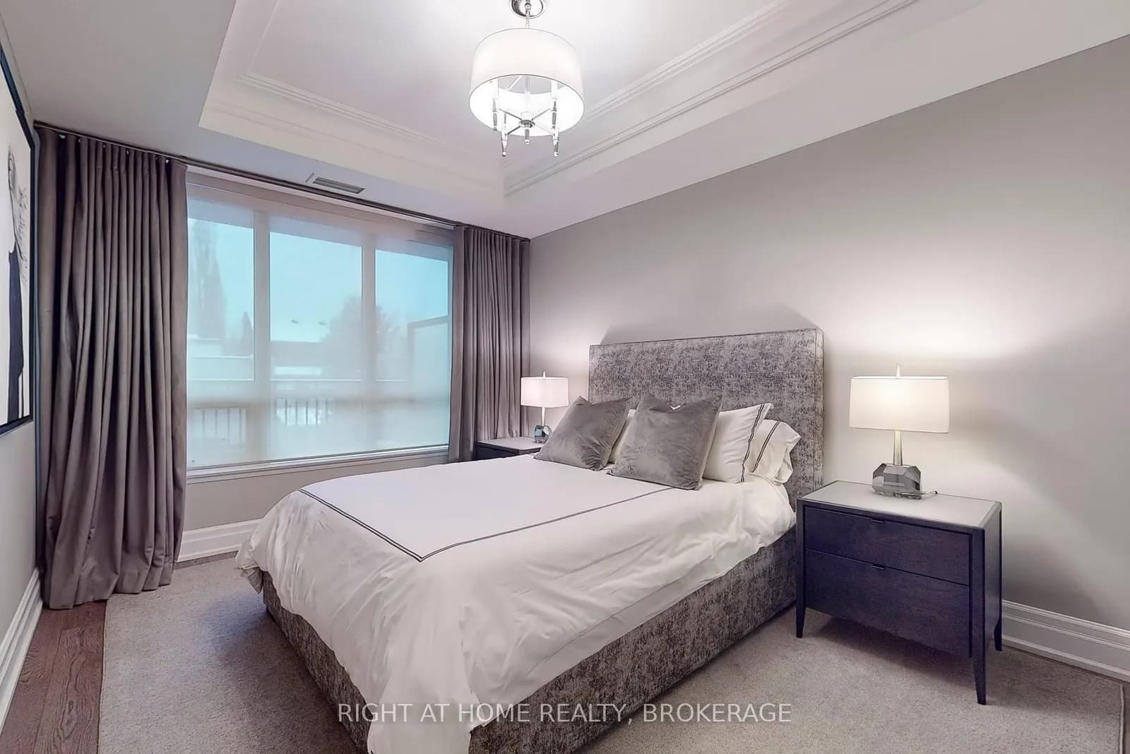 Bedroom with an upholstered headboard and a large window