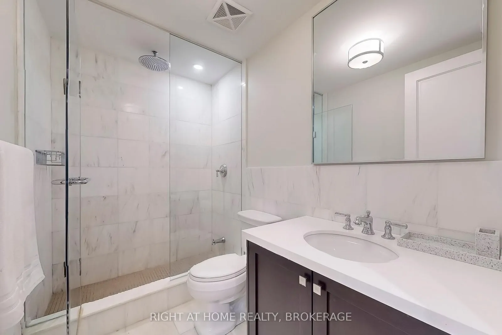 Bathroom with a glass-walled shower and marble tile