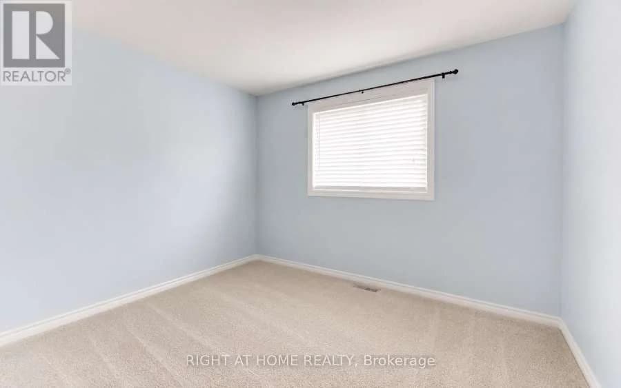 Carpeted bedroom with pale blue walls and a window