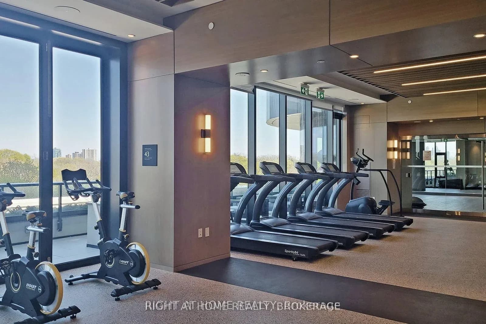 Building gym with treadmills and bikes facing the windows