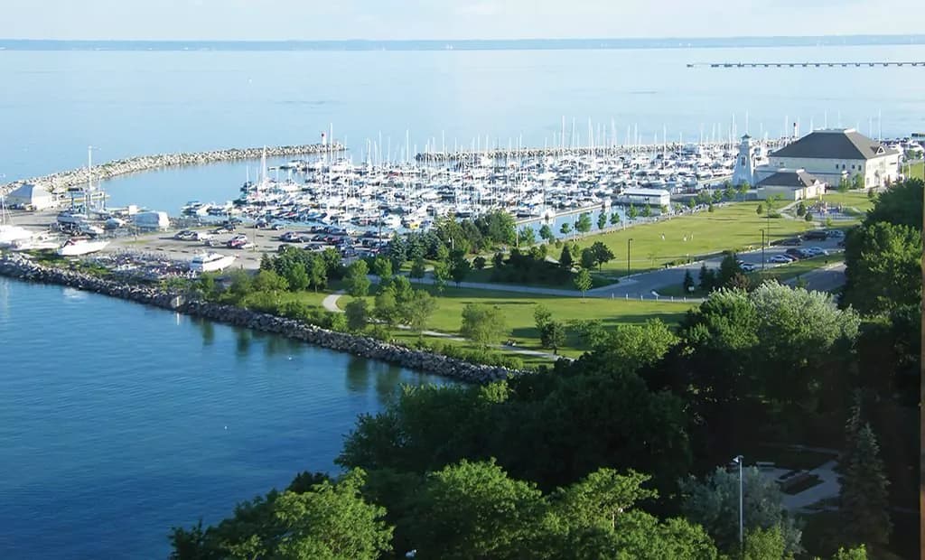 A harbour and breakwater seen from a wooded bluff above the lake